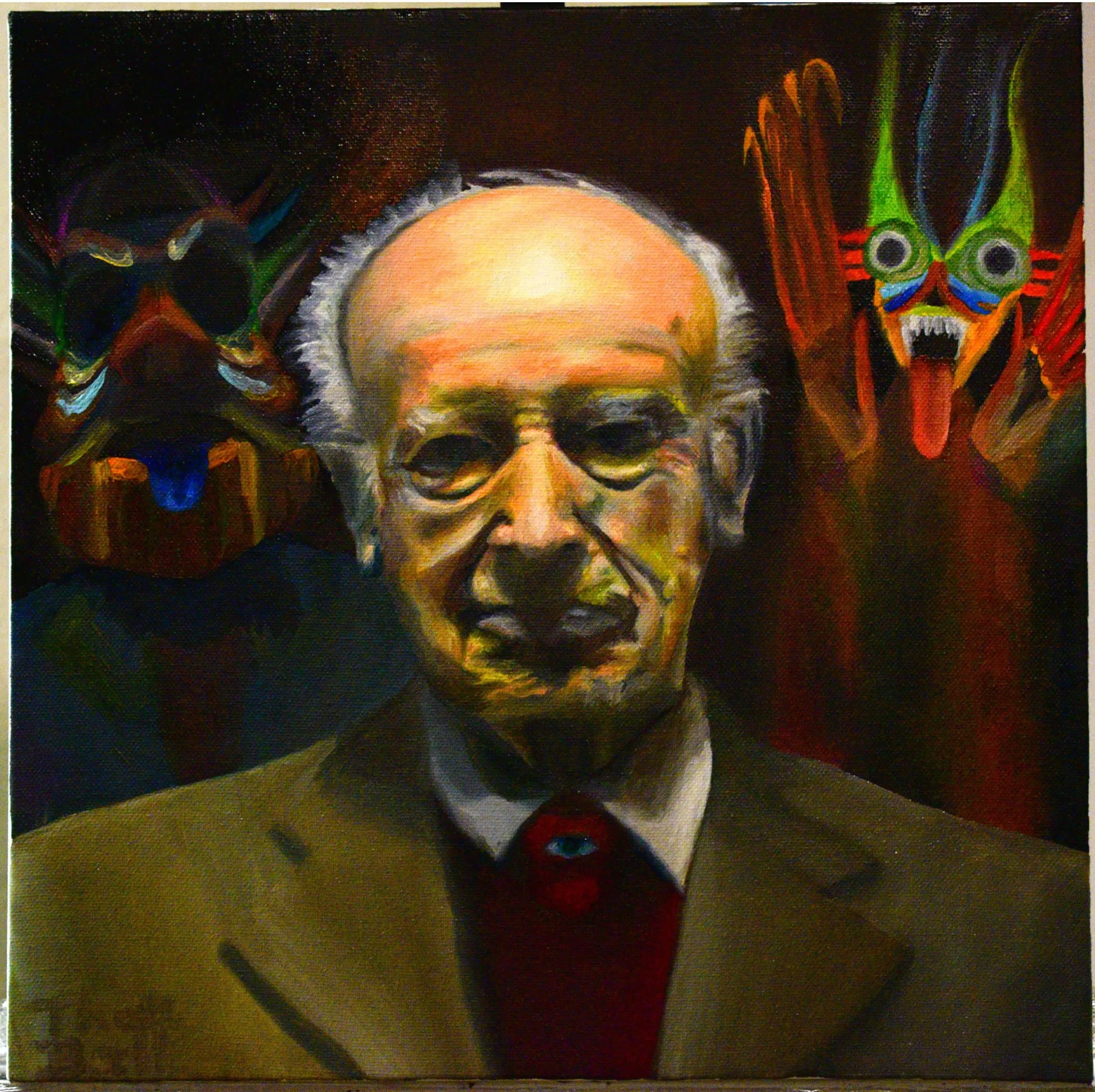 Portrait of an elderly bald man with glasses in a brown jacket and red tie, flanked by two colorful masks