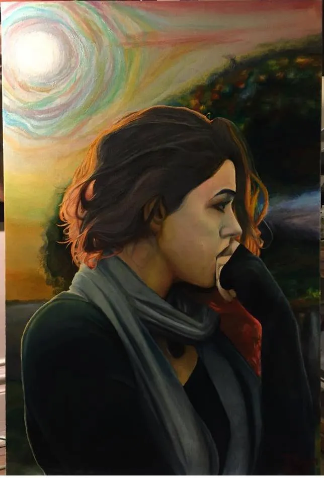 Woman in a dark coat and gray scarf with her hand at her cheek, against a sunset landscape